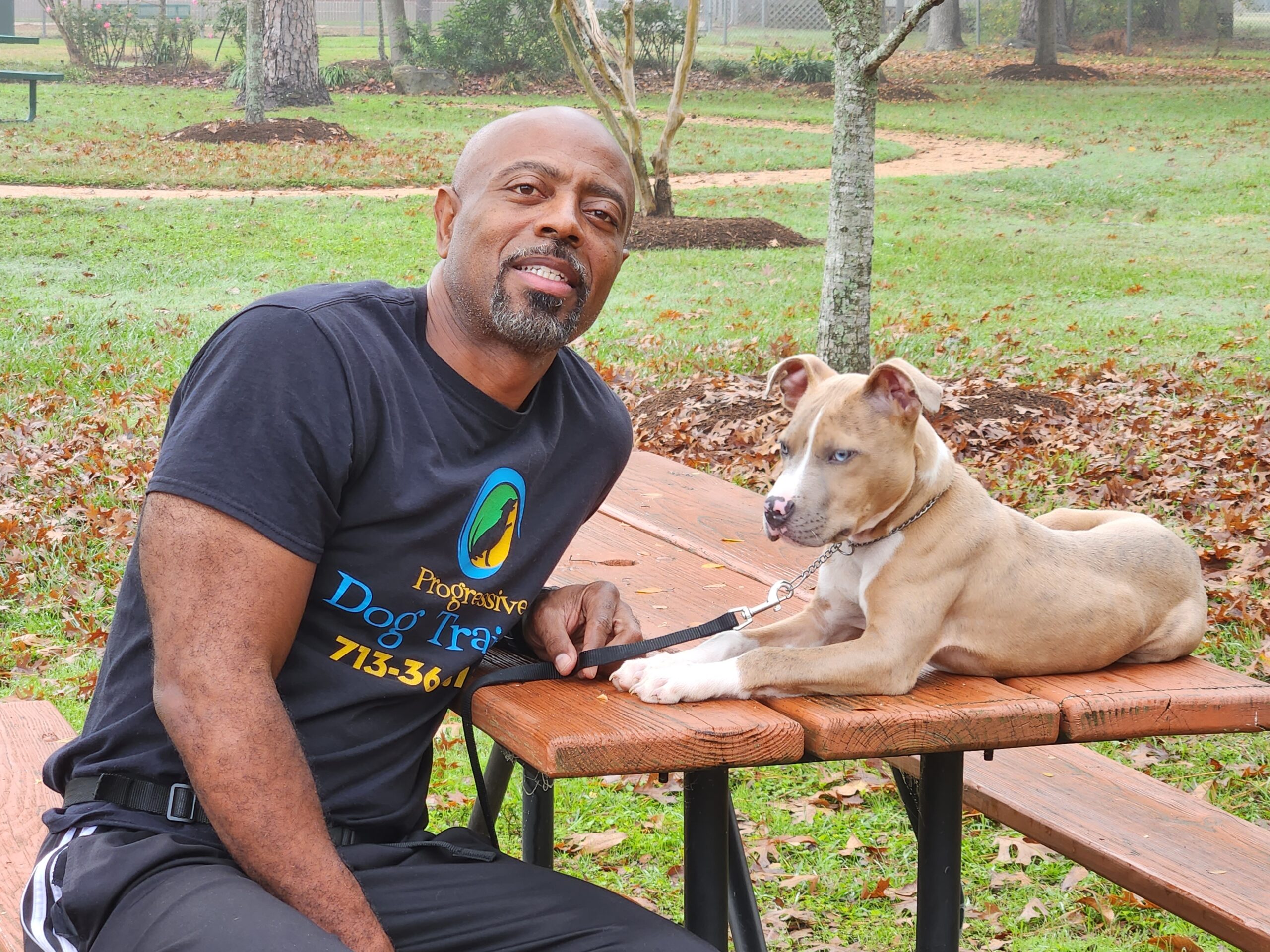A Trainer Sitting On A Bench With A Dog